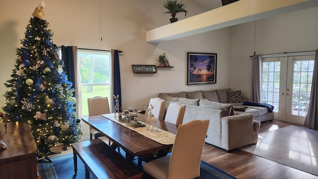 dining space with dark hardwood / wood-style flooring, french doors, a towering ceiling, and plenty of natural light