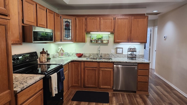 kitchen with kitchen peninsula, light stone countertops, dark hardwood / wood-style flooring, black appliances, and a breakfast bar area