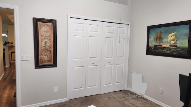 unfurnished bedroom featuring dark colored carpet and a closet