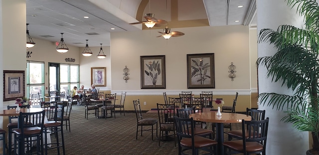 carpeted dining area with ceiling fan