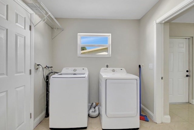 laundry area featuring washer and clothes dryer and light tile patterned floors