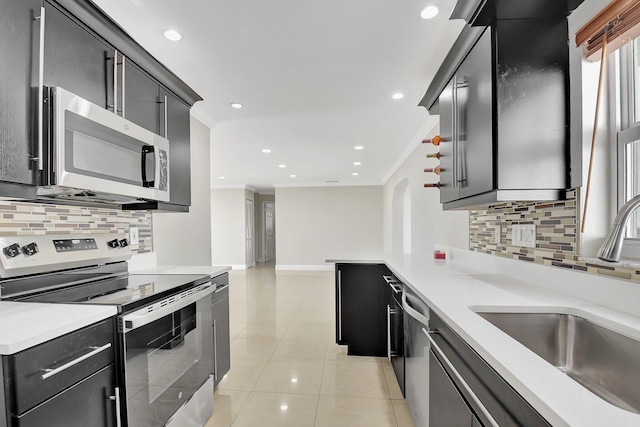 kitchen featuring appliances with stainless steel finishes, tasteful backsplash, light tile patterned floors, and sink