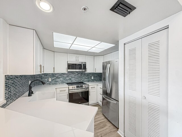 kitchen with white cabinets, appliances with stainless steel finishes, and sink