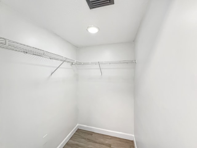 spacious closet with wood finished floors and visible vents