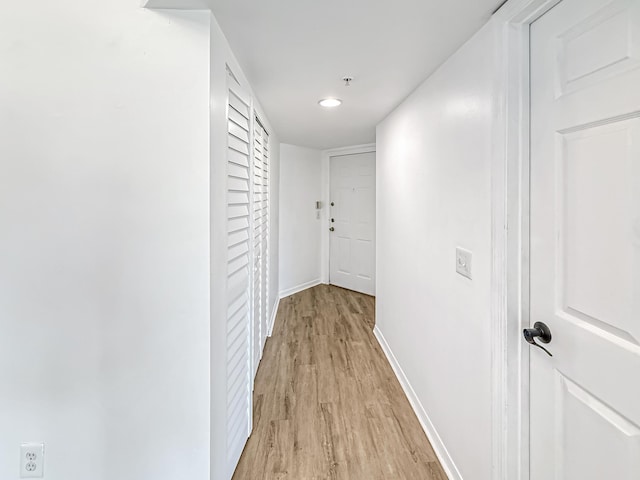 hallway with light wood-style flooring and baseboards