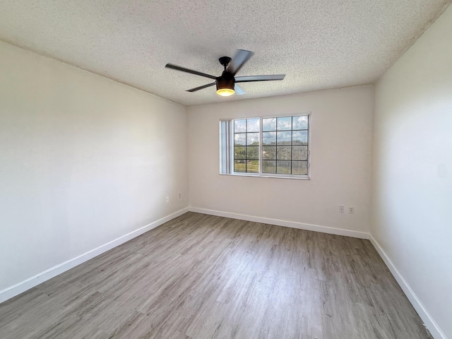 unfurnished room featuring a ceiling fan, baseboards, a textured ceiling, and light wood finished floors