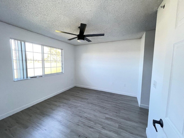 empty room featuring a textured ceiling, dark hardwood / wood-style floors, and ceiling fan