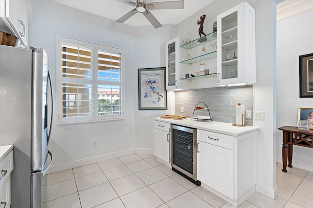 kitchen with stainless steel fridge, backsplash, light tile patterned floors, white cabinets, and wine cooler