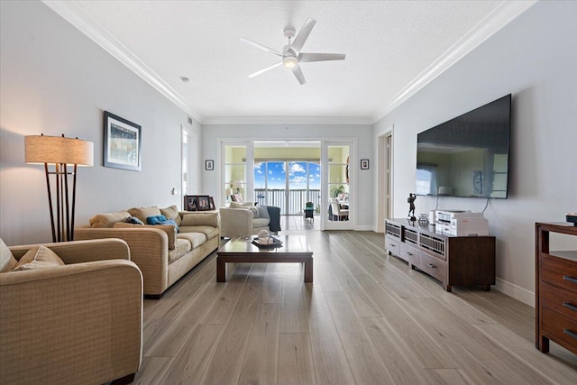 living room with ceiling fan, light hardwood / wood-style floors, ornamental molding, and a textured ceiling