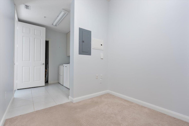 corridor with washing machine and clothes dryer, electric panel, and light colored carpet