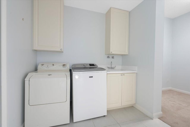 washroom featuring washer and dryer, cabinets, light tile patterned floors, and sink