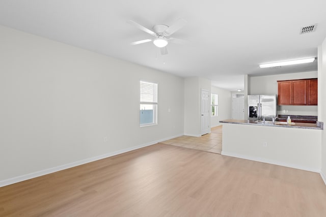 kitchen featuring stainless steel refrigerator with ice dispenser, light wood-type flooring, and ceiling fan