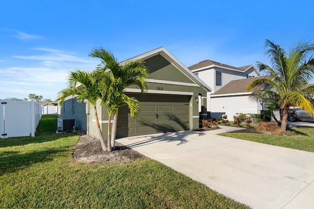 view of front of home featuring cooling unit, a garage, and a front lawn