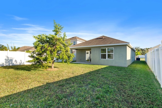 rear view of house with a yard and a patio