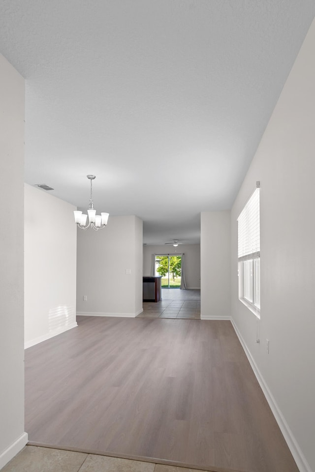 unfurnished room featuring hardwood / wood-style flooring and a chandelier