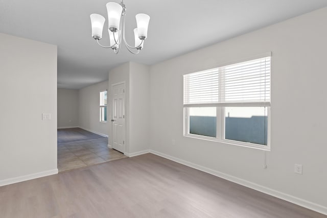 empty room featuring a chandelier and hardwood / wood-style flooring