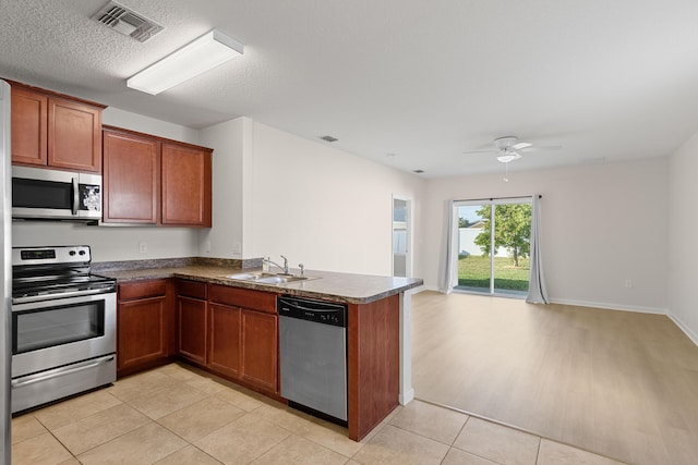 kitchen with sink, ceiling fan, appliances with stainless steel finishes, light hardwood / wood-style floors, and kitchen peninsula