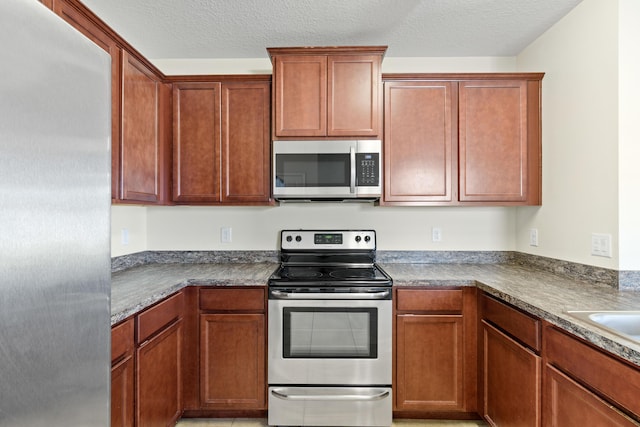 kitchen featuring appliances with stainless steel finishes and a textured ceiling