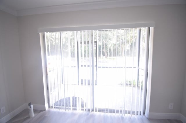 doorway to outside with wood-type flooring and crown molding