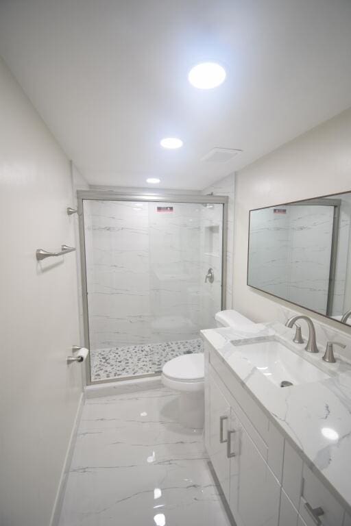 bathroom featuring vanity, toilet, and walk in shower