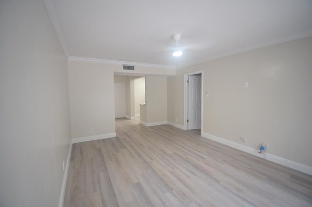 empty room featuring light hardwood / wood-style flooring and ornamental molding