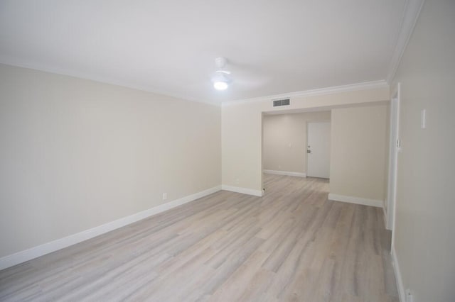 empty room with crown molding and light hardwood / wood-style flooring