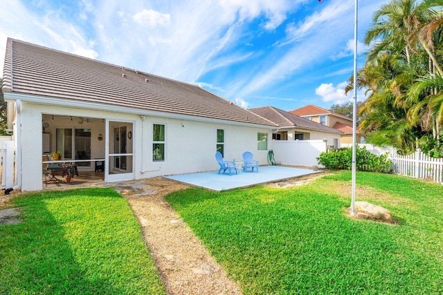 rear view of property featuring a yard and a patio