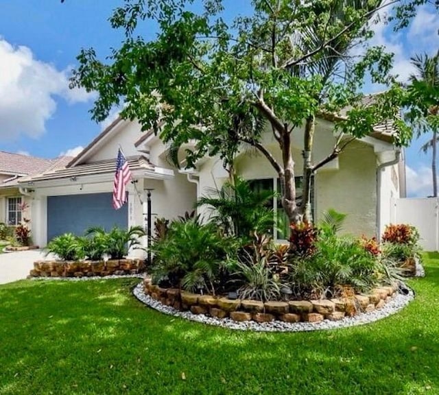 view of front of home featuring a garage and a front lawn