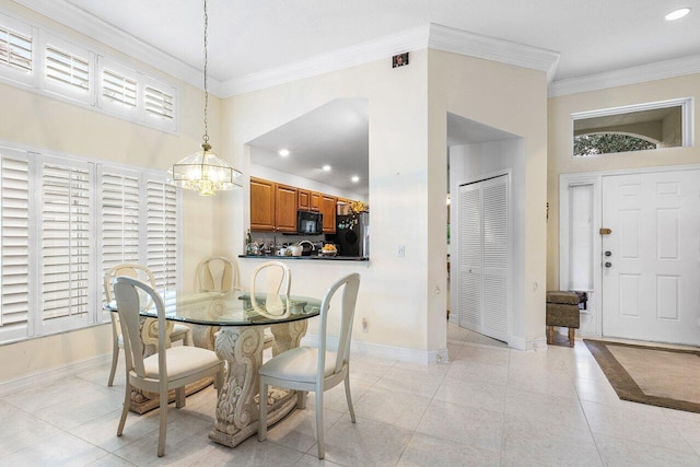 dining room with a notable chandelier, light tile patterned floors, and crown molding