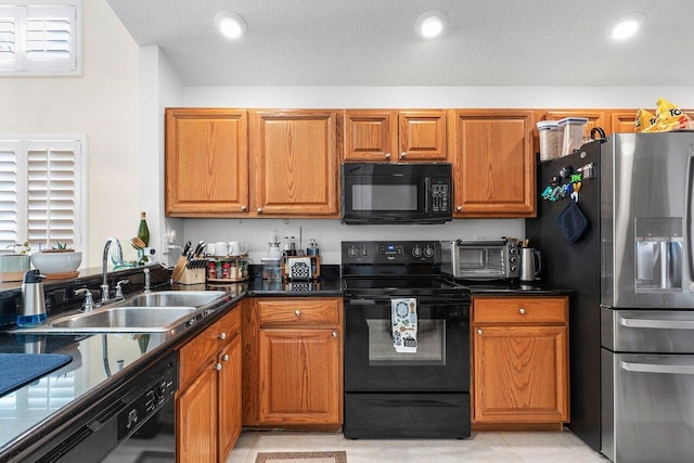 kitchen featuring black appliances, light tile patterned floors, and sink