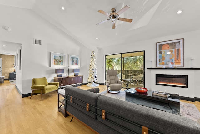 living room featuring ceiling fan, high vaulted ceiling, and light wood-type flooring