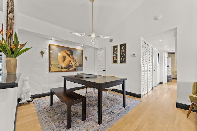 dining room with lofted ceiling, light hardwood / wood-style floors, and a healthy amount of sunlight