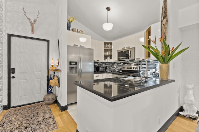 kitchen with kitchen peninsula, white cabinetry, light wood-type flooring, and appliances with stainless steel finishes