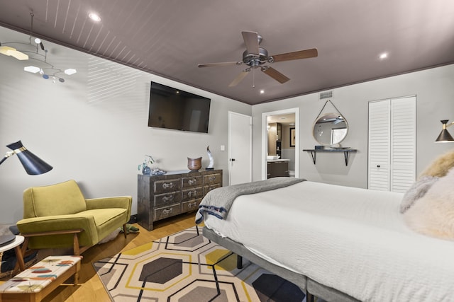 bedroom featuring ceiling fan, a closet, ensuite bathroom, and light hardwood / wood-style flooring