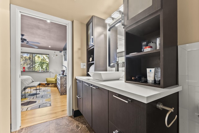 kitchen featuring dark brown cabinets, ceiling fan, dark wood-type flooring, and sink