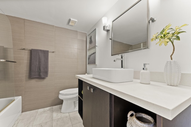 bathroom with tile patterned floors, vanity, tile walls, and toilet