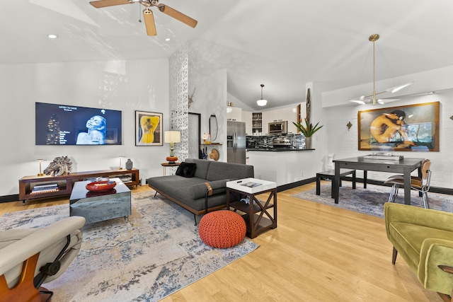 living room with light wood-type flooring, ceiling fan, and lofted ceiling