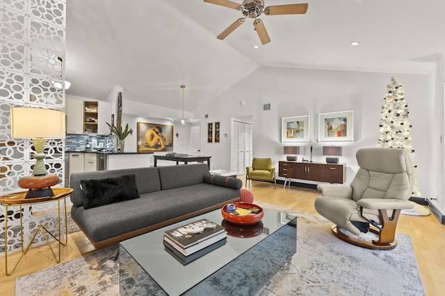 living room featuring ceiling fan, high vaulted ceiling, and light hardwood / wood-style floors