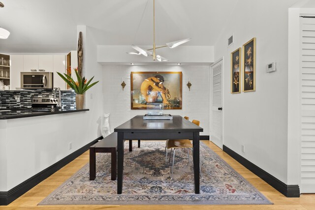 home office featuring light hardwood / wood-style flooring and a notable chandelier