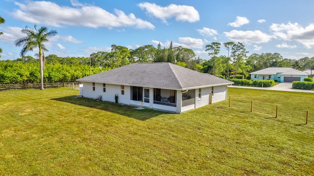 back of house featuring a sunroom and a yard