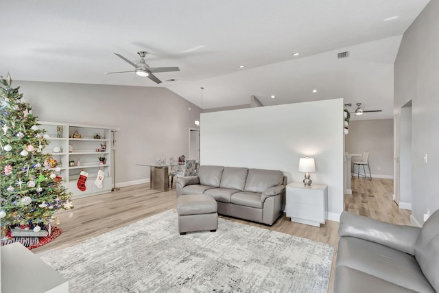 living room featuring ceiling fan, lofted ceiling, and light hardwood / wood-style flooring