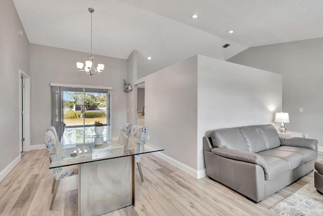 dining space featuring light hardwood / wood-style floors, high vaulted ceiling, and a chandelier