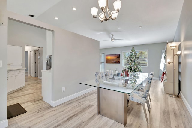 dining space with light hardwood / wood-style floors and ceiling fan with notable chandelier