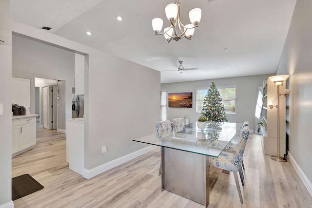 dining space with light hardwood / wood-style floors and ceiling fan with notable chandelier