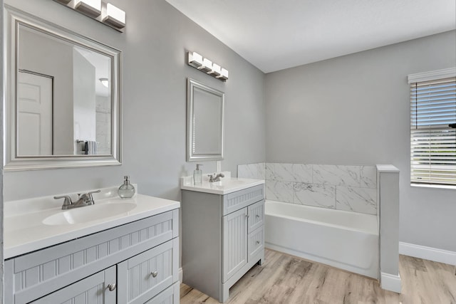 bathroom featuring a tub to relax in, vanity, and hardwood / wood-style flooring