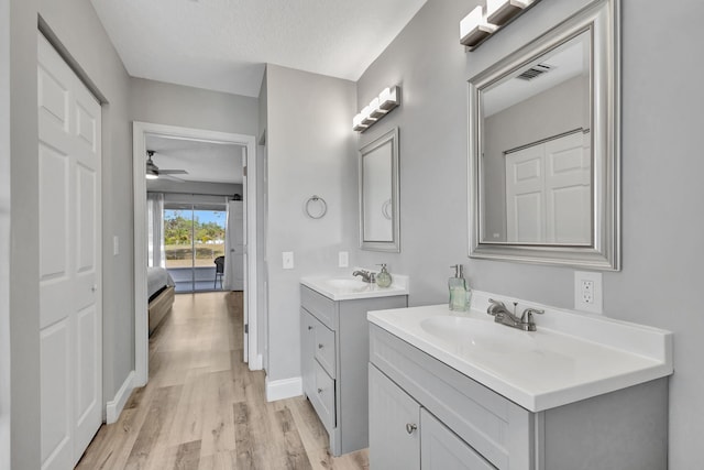 bathroom featuring ceiling fan, vanity, a textured ceiling, and hardwood / wood-style flooring