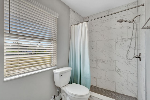 bathroom featuring toilet and curtained shower