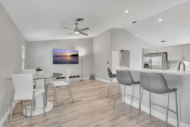 dining room featuring ceiling fan, light hardwood / wood-style flooring, and lofted ceiling