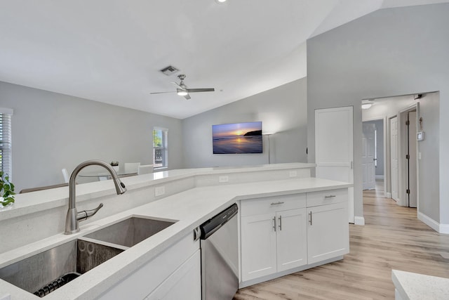 kitchen with white cabinets, vaulted ceiling, sink, dishwasher, and light hardwood / wood-style floors