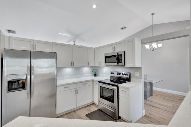 kitchen with stainless steel appliances, a notable chandelier, light hardwood / wood-style floors, lofted ceiling, and decorative light fixtures